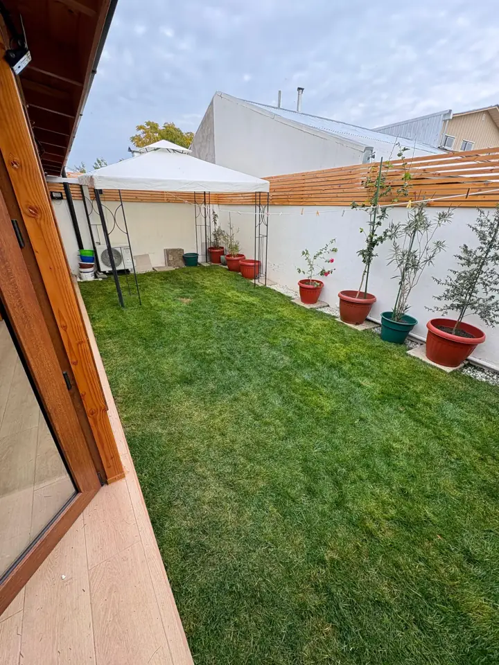 Patio con toldo y césped